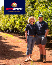 Load image into Gallery viewer, Owners of Red Rock Macadamias Fiona and Jason Klotz standing in their orchard